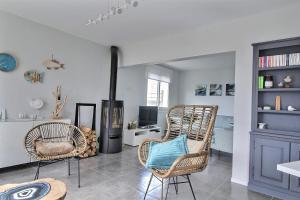 ein Wohnzimmer mit zwei Stühlen und einem Kamin in der Unterkunft le toul braz in Saint-Gildas-de-Rhuys