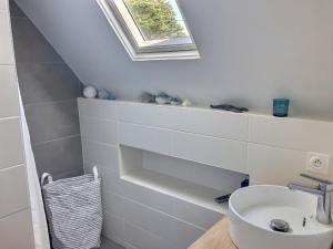 ein weißes Badezimmer mit Waschbecken und Fenster in der Unterkunft le toul braz in Saint-Gildas-de-Rhuys
