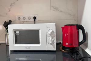 a microwave sitting on a counter next to a coffee maker at Meta Habitat Ramon Lujan B in Madrid