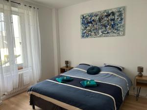 1 dormitorio con 1 cama con sábanas azules y una pintura en BnB Maison d'Art Breakfast in the Art Gallery en Ploubazlanec