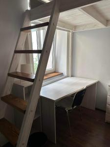 a loft bed with a desk and a chair in a room at Cozy rooms in Old Town and Wawel in Krakow