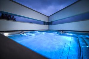 a large swimming pool with blue lights in a room at ALEXBAD Ferienwohnungen in Bad Alexandersbad