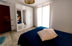 a bedroom with a blue bed and a large window at Patty's room in Villasimius