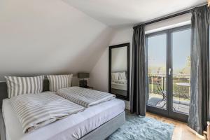 a bedroom with a bed and a large window at Horst Wai Hues in Westerland (Sylt)