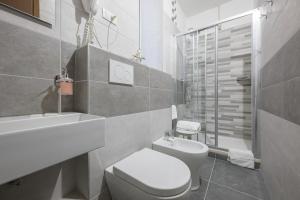 Baño blanco con aseo y lavamanos en Affittacamere Berzi, en Trieste