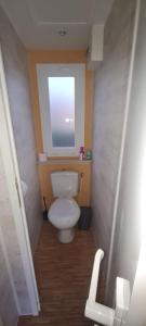 a small bathroom with a toilet with a window at Mobil Home 3 chambres 6 pers 1/2h PUY du FOU in La Boissière-de-Montaigu
