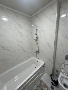 a white bathroom with a tub and a toilet at Lux Istanbul City in Yakkasaray