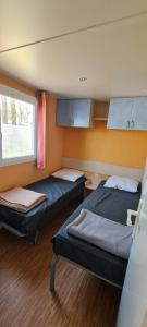 a room with two beds and a window at Mobil Home 3 chambres 6 pers 1/2h PUY du FOU in La Boissière-de-Montaigu