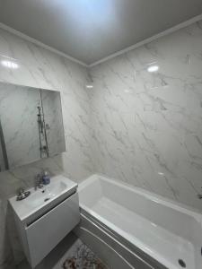 a white bathroom with a tub and a sink at Lux Istanbul City in Yakkasaray
