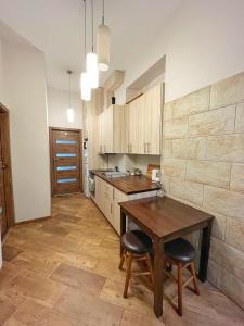 a kitchen with a wooden table and two stools at Cozy rooms in Old Town and Wawel in Krakow