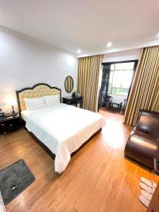 河內的住宿－Nhật Tân Hotel，卧室配有一张白色大床和一把椅子