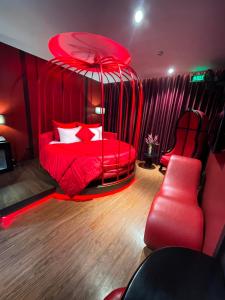 ハノイにあるNhật Tân Hotelの赤いベッドと赤い椅子2脚が備わる赤いベッドルーム1室が備わります。