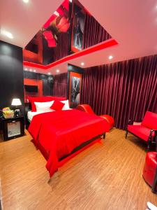 ハノイにあるNhật Tân Hotelの赤いベッドルーム(赤いベッド1台、椅子付)