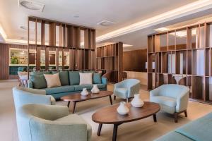 a lobby with couches and chairs and tables at NAU Sao Rafael Suites - All Inclusive in Albufeira
