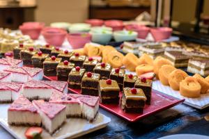 a table topped with lots of different types of desserts at NAU Sao Rafael Suites - All Inclusive in Albufeira