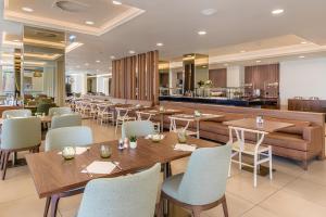 a restaurant with wooden tables and chairs and a bar at NAU Sao Rafael Suites - All Inclusive in Albufeira