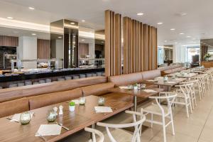 a restaurant with tables and chairs and a bar at NAU Sao Rafael Suites - All Inclusive in Albufeira