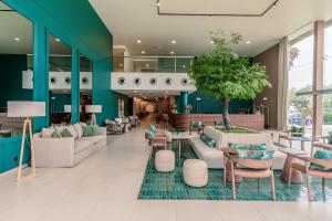 a lobby with couches and tables and chairs at NAU Sao Rafael Suites - All Inclusive in Albufeira