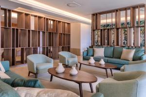 a lobby with couches and chairs and tables at NAU Sao Rafael Suites - All Inclusive in Albufeira