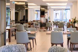 a dining room with tables and chairs and a cafeteria at NAU Sao Rafael Suites - All Inclusive in Albufeira