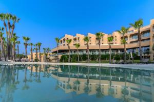 un edificio con palmeras y piscina en NAU Sao Rafael Suites - All Inclusive, en Albufeira