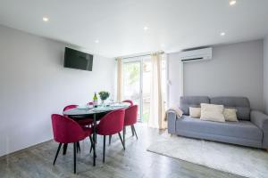 a living room with a couch and a table and chairs at Maison sur L'eau in Cergy