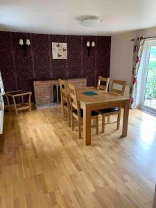 uma sala de jantar com uma mesa e cadeiras e uma lareira em Gullers End Farm Cottage em Long Green