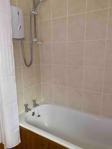 ein Badezimmer mit Badewanne und Dusche in der Unterkunft Gullers End Farm Cottage in Long Green + 3 Fotos