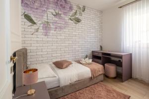 a bedroom with a bed and a brick wall at VIPo Seget Apartments in Trogir