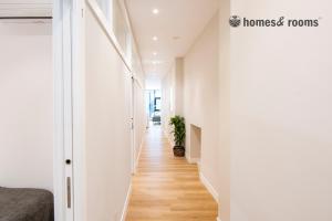 a hallway with white walls and wooden floors at Enorme apartamento con 4 baños in Santiago de Compostela