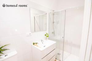 a white bathroom with a shower and a sink at Enorme apartamento con 4 baños in Santiago de Compostela