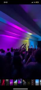 una folla di persone in una stanza con luci viola di Events Hause a Gammarth