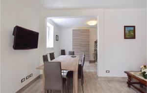 a dining room with a table and a television on a wall at Villetta Alessandro in Capezzano Pianore,