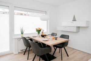 a dining room with a wooden table and chairs at Lüttje Nest in Norderney