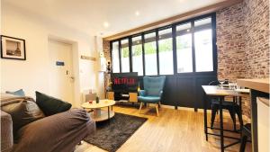 a living room with a couch and a table at L'industriel - Tout confort in Saint-Brieuc