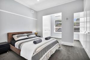 a bedroom with a bed with two pillows on it at Stylish, Sunny & Spacious 2 Bedroom Apartment, Mosman in Sydney