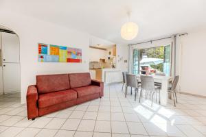 a living room with a red couch and a table at Villino Straccoligno - Goelba in Capoliveri