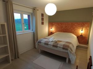 a bedroom with a bed and a large window at Maison de campagne 6 pers avec chemins de randonnée et station thermale à proximité - FR-1-589-631 in Montmotier