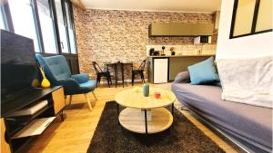 a living room with a couch and a table at L'industriel - Tout confort in Saint-Brieuc