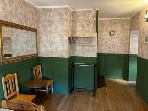 a room with green walls and a table and chairs at Hostel Retro in Krakow