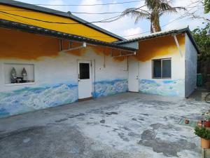 une maison avec une fresque murale sur son côté dans l'établissement Kenting Sun & Sea B&B, à Nanwan