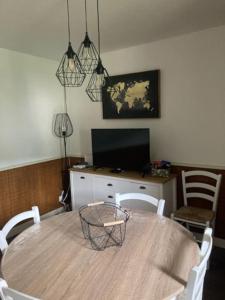 ein Esszimmer mit einem Tisch mit Stühlen und einem TV in der Unterkunft Ravissant appartement au cœur de Piana in Piana