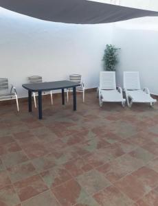 stół i 2 krzesła oraz stół i krzesła w obiekcie Casa Moli w mieście Barbate