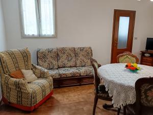 sala de estar con sofá y mesa en Casa Revignano, nostalgica oasi dei nonni, en La Loggia