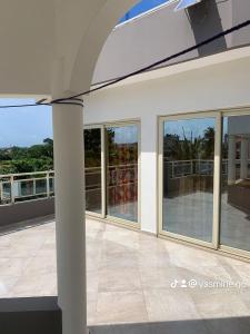 a house with glass windows and a balcony at Yasmine Immo in Cotonou