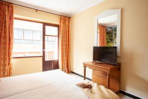 シジョットにあるBJ Hostal Bona Vistaのベッドルーム1室(ベッド2台、テレビ、鏡付)