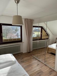 a bedroom with a bed and two windows at Haus Cornelia in Einruhr