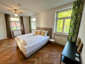 a bedroom with a large white bed and two windows at Auszeit im Bad Diezlings in Hörbranz