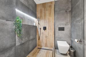 a bathroom with a toilet and a plant on the wall at LAM City Jungle - SKY VIEW 21 FLOOR - Free Parking in Bratislava +16 photos