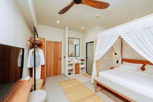 a bedroom with a bed and a ceiling fan at Samawa Living in Paje